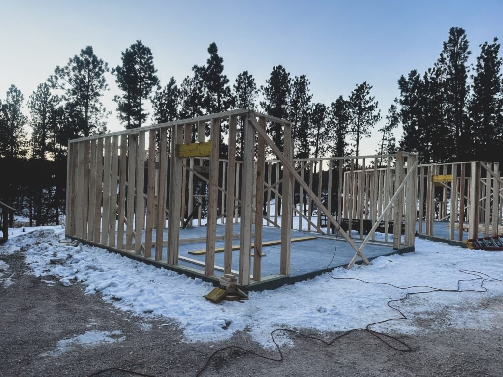 Wooden frames of a house under construction on a snowy winter morning in Custer, SD.